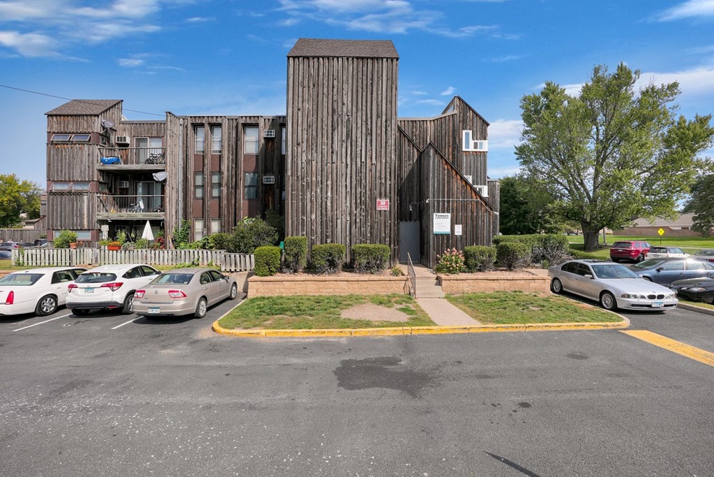 a parking lot with cars parked in front of a wooden building