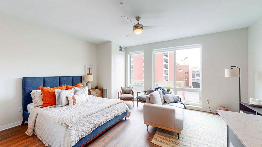 a bedroom with a bed and a couch and a large window