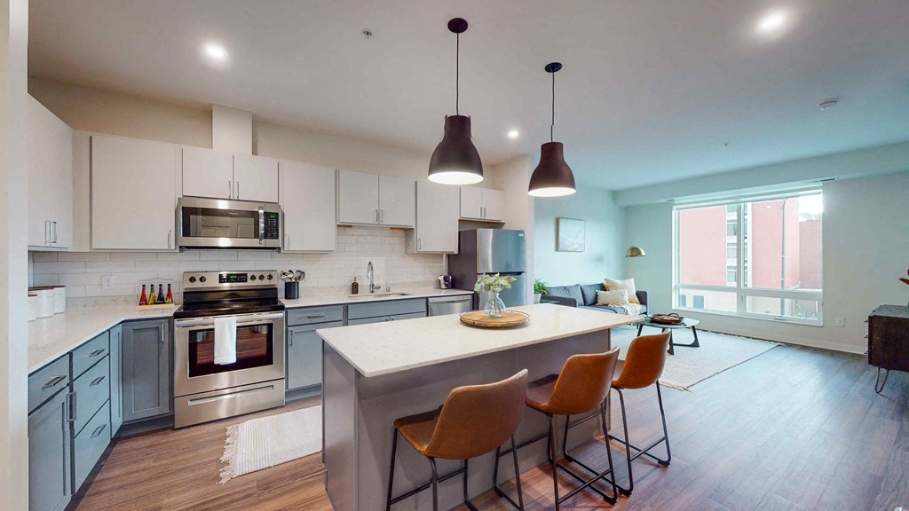 a kitchen and living room with an island and chairs