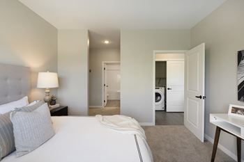 A bedroom with a bed, nightstand, and a lamp at The Barnum Apartments, White Bear Lake, Minnesota