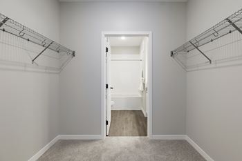 A white door is open in a room with white walls and a carpeted floor at The Barnum Apartments, White Bear Lake, 55110