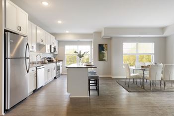 A modern kitchen with dinning area at The Barnum Apartments, White Bear Lake, MN,  55110