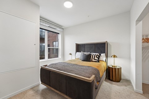 A bedroom with a large bed and a window.