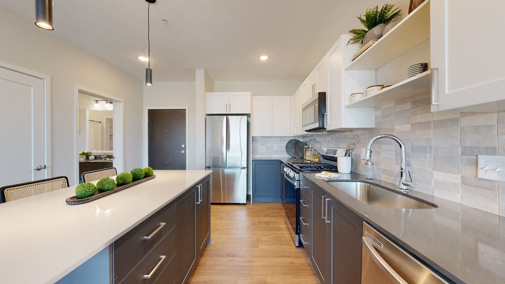 a kitchen with white countertops and gray cabinets