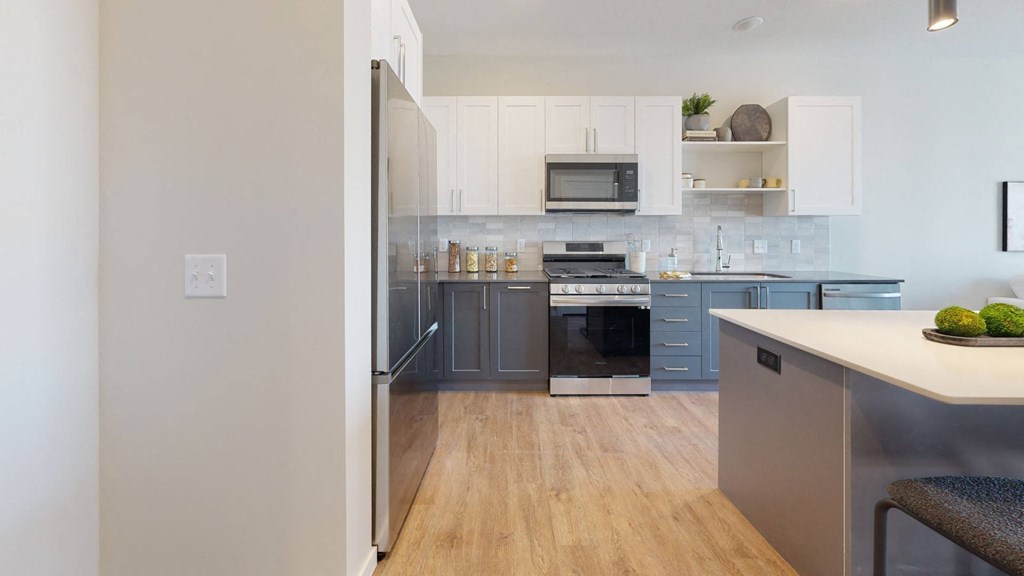 a kitchen with white cabinets and a wooden floor