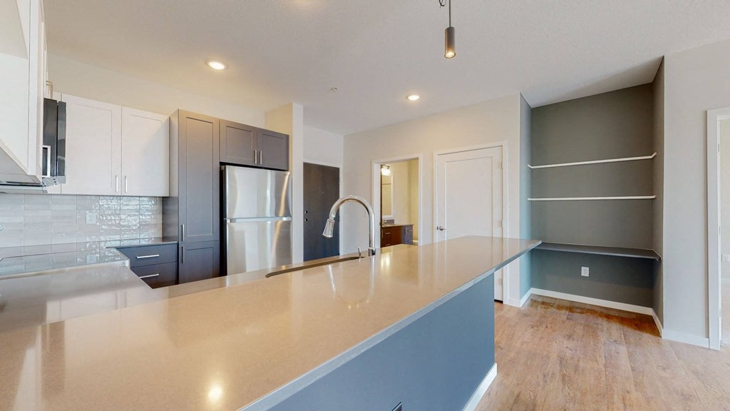 a kitchen with a large counter and a refrigerator
