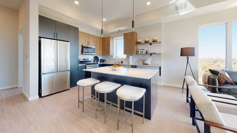 a kitchen with a large center island with three stools