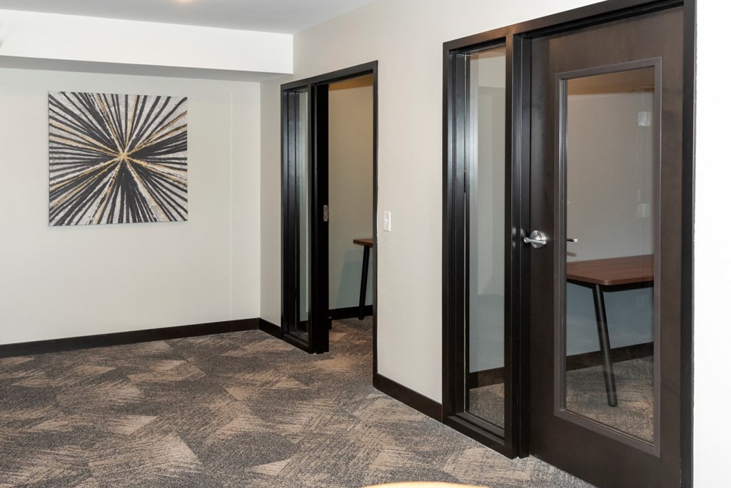 a hallway with three doors and a painting on the wall