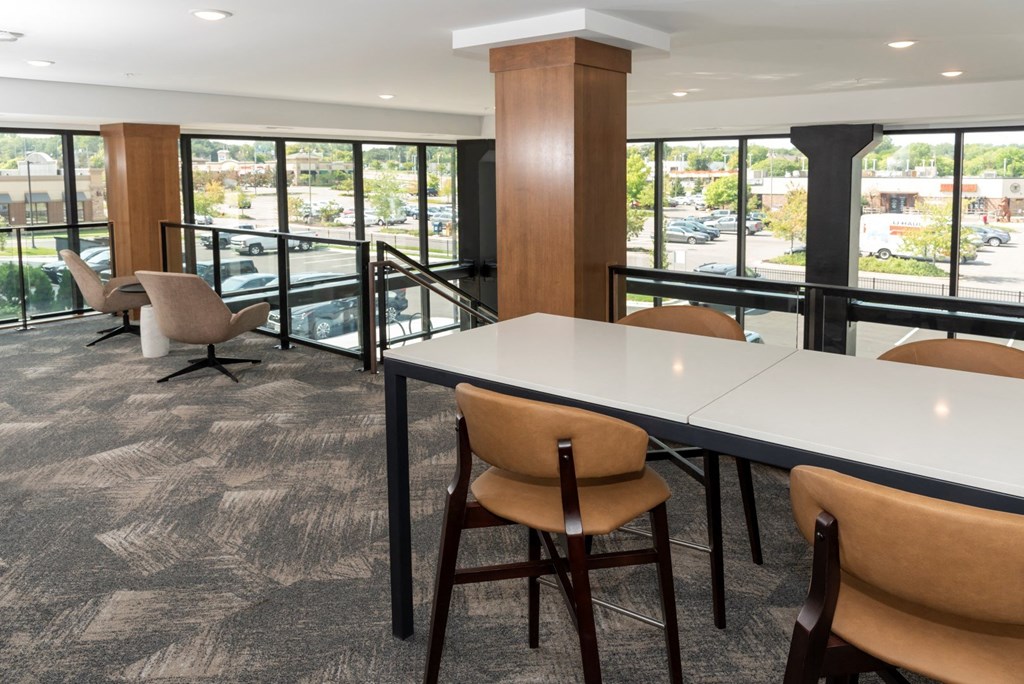 a room with a long table and chairs with a view of a parking lot
