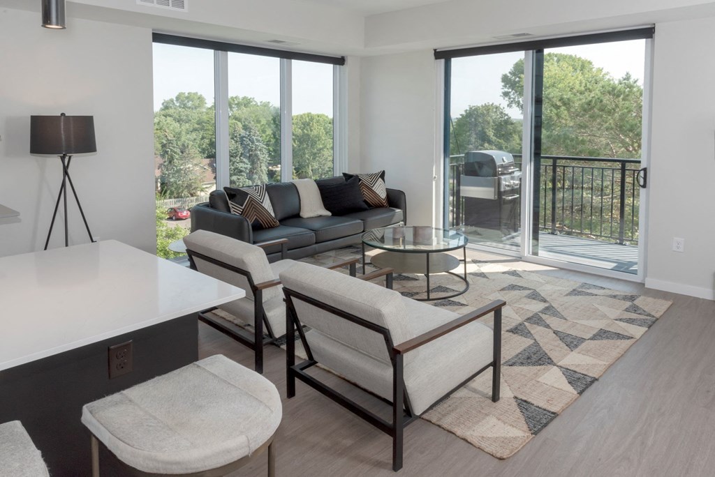 a living room with a couch table and chairs and sliding glass doors