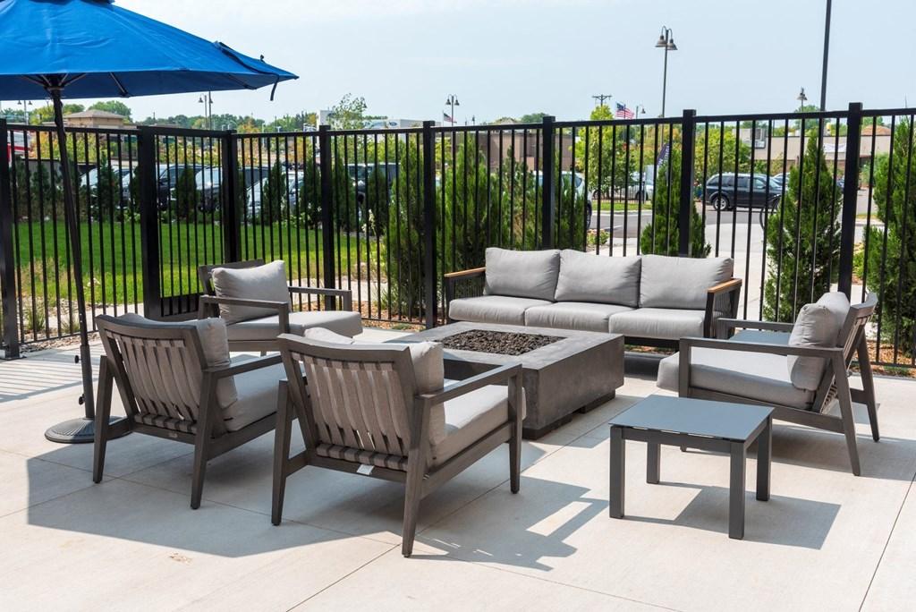 a patio with a couch and chairs and a fire pit