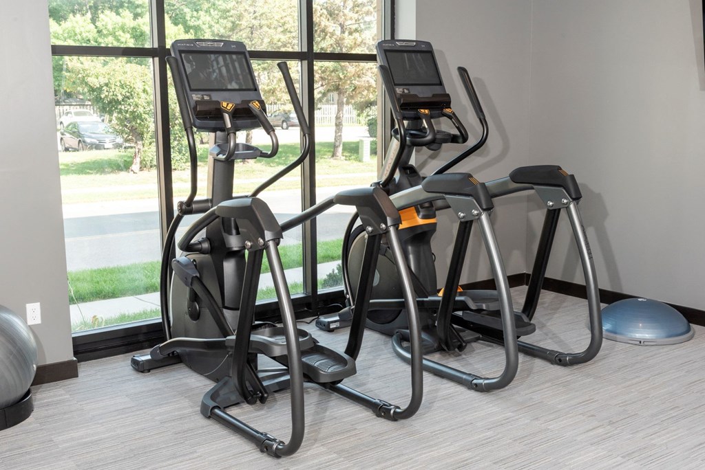 a row of exercise bikes in front of a window