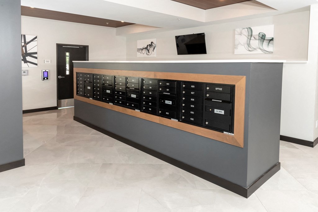 a mail room with a large wooden door and a television on the wall