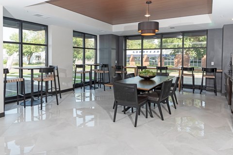 a dining room with a table and chairs in front of a wall of windows