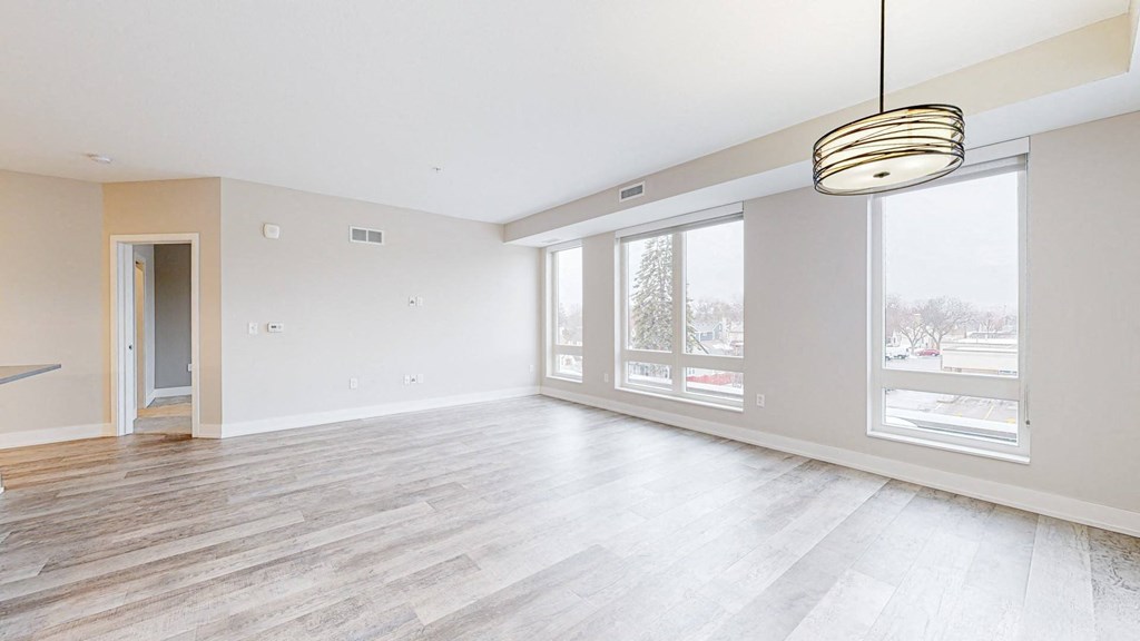 the living room with hardwood floors and large windows