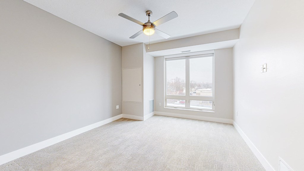 a bedroom with a ceiling fan and a window