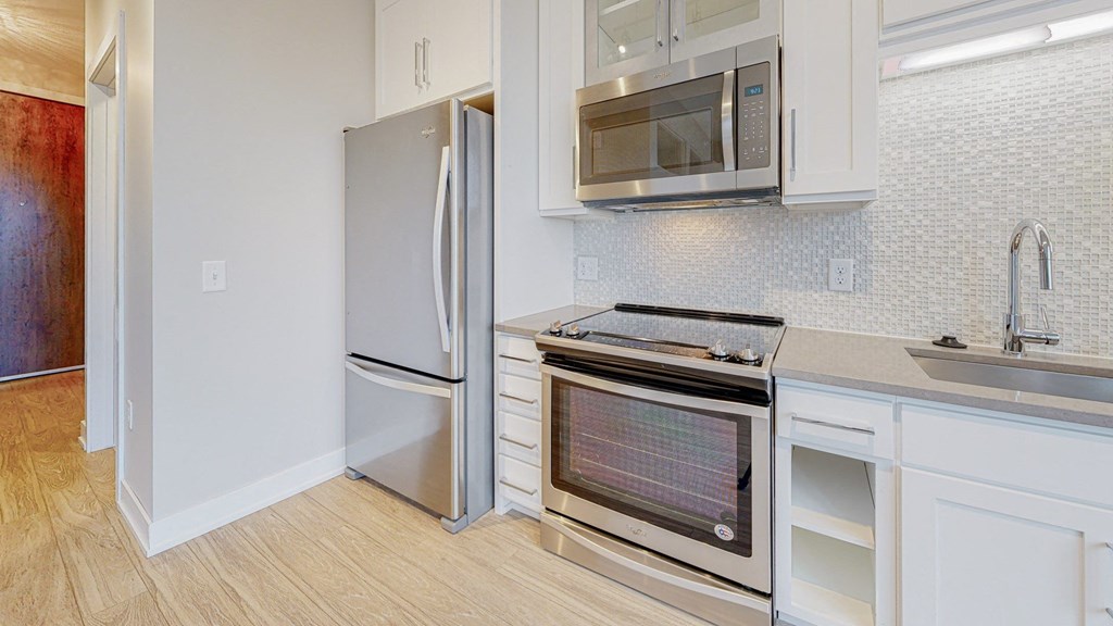 a kitchen with white cabinets and stainless steel appliances