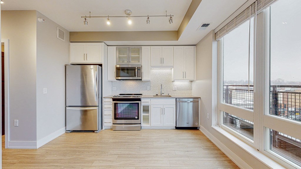 a kitchen with white cabinets and stainless steel appliances