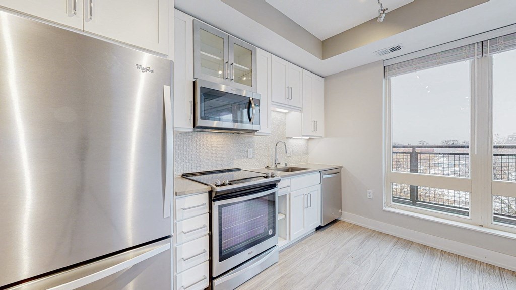 a kitchen with white cabinets and stainless steel appliances