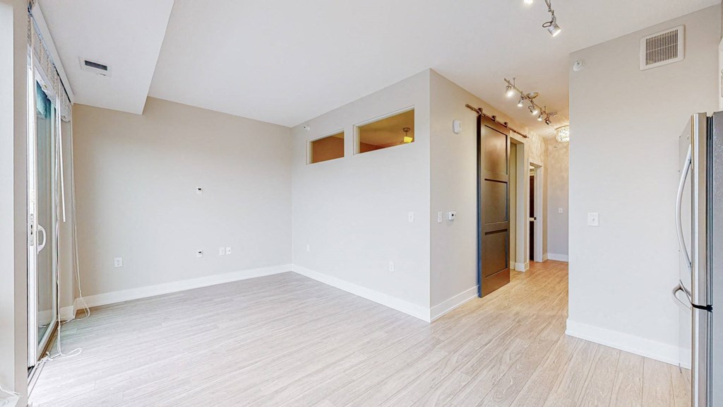 a bedroom with hardwood floors and white walls
