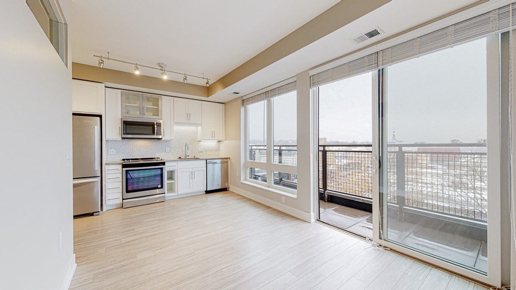 a kitchen and living room with floor to ceiling windows