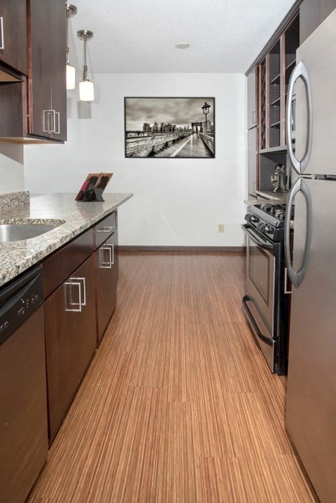 a kitchen with wood flooring and stainless steel appliances