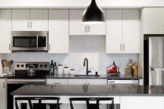 White Cabinetry With Sleek, Silver Appliances at The Hill Apartments, Saint Paul, Minnesota