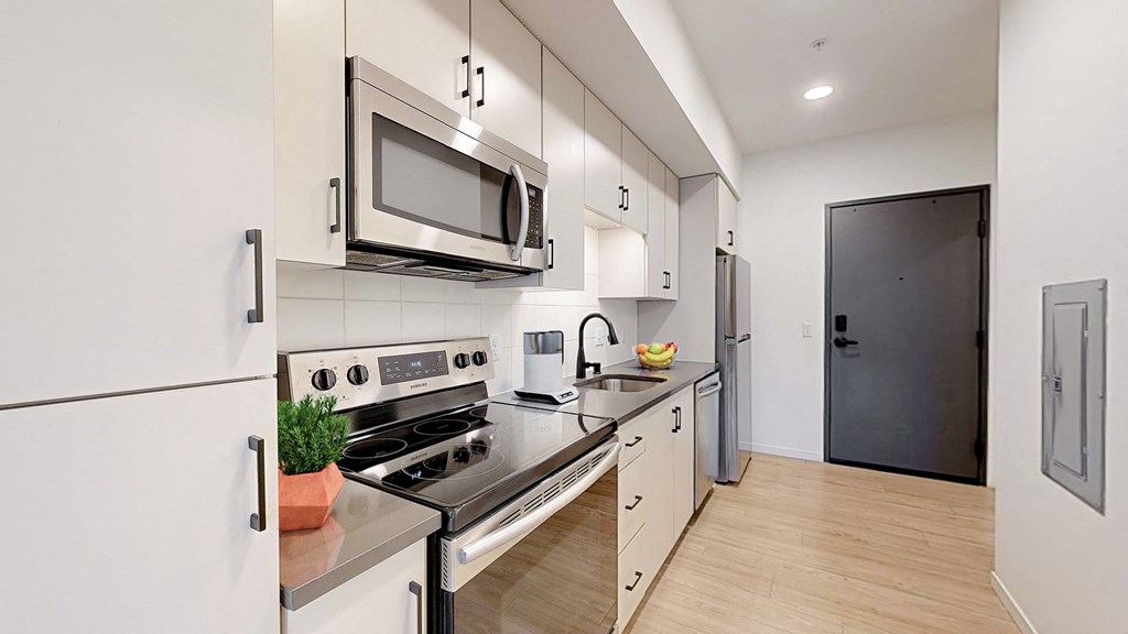 A modern kitchen with a stove, oven, microwave, and refrigerator. at The Hill Apartments, Saint Paul, MN, 55102