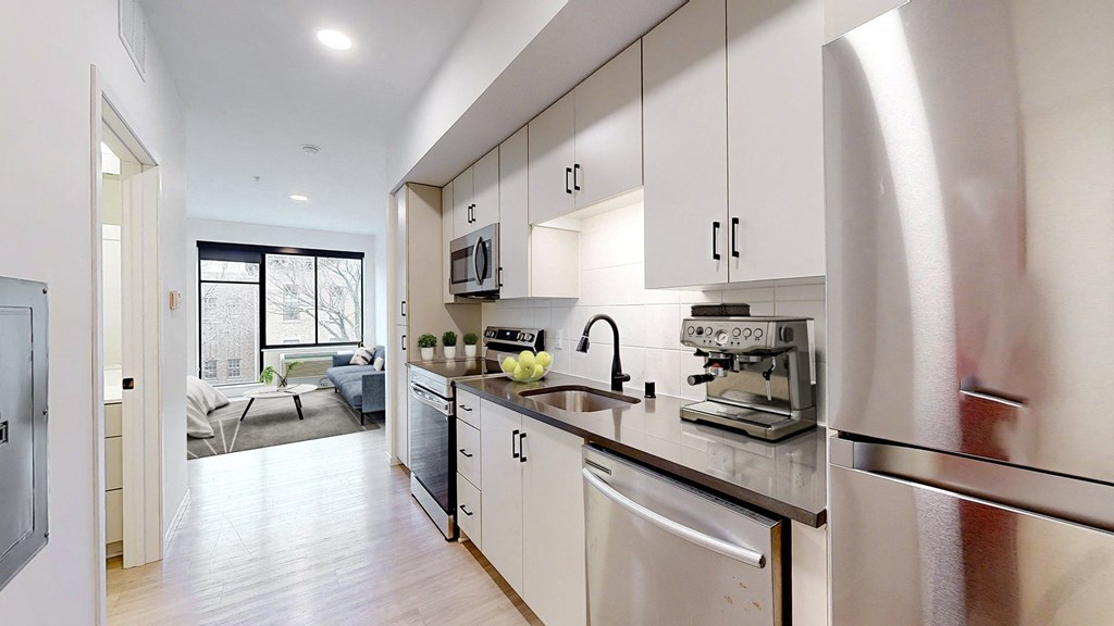 A modern kitchen with stainless steel appliances and white cabinets. at The Hill Apartments, Saint Paul, 55102
