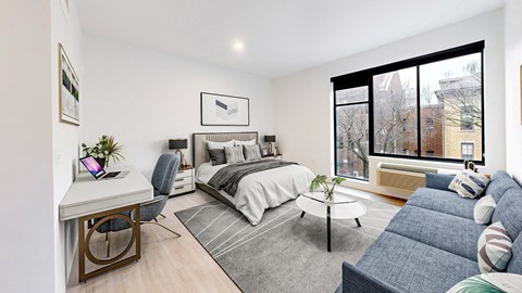 A well-lit bedroom with a bed, desk, and chair.