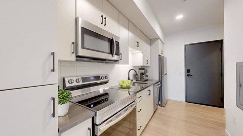 A modern kitchen with a stove, oven, microwave, and refrigerator.