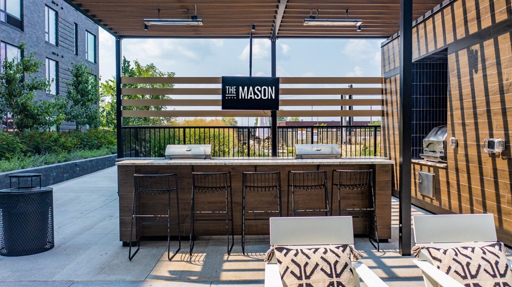 an outdoor patio with a bar and chairs