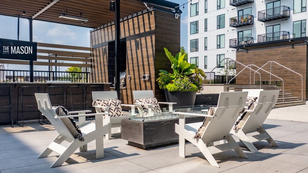 a terrace with a table and chairs in front of a building