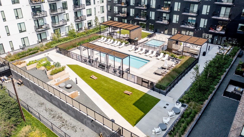 an aerial view of an apartment complex with a pool and grassy area