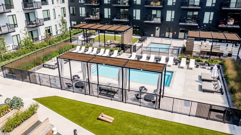 an aerial view of an apartment complex with a pool and lounge chairs