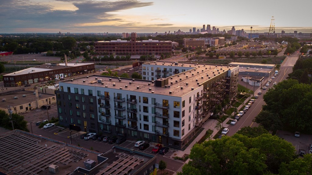an aerial view of an apartment building with a city skyline in the background