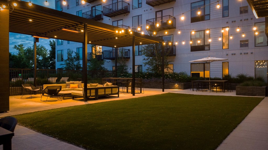 the patio of an apartment building at night with a lawn