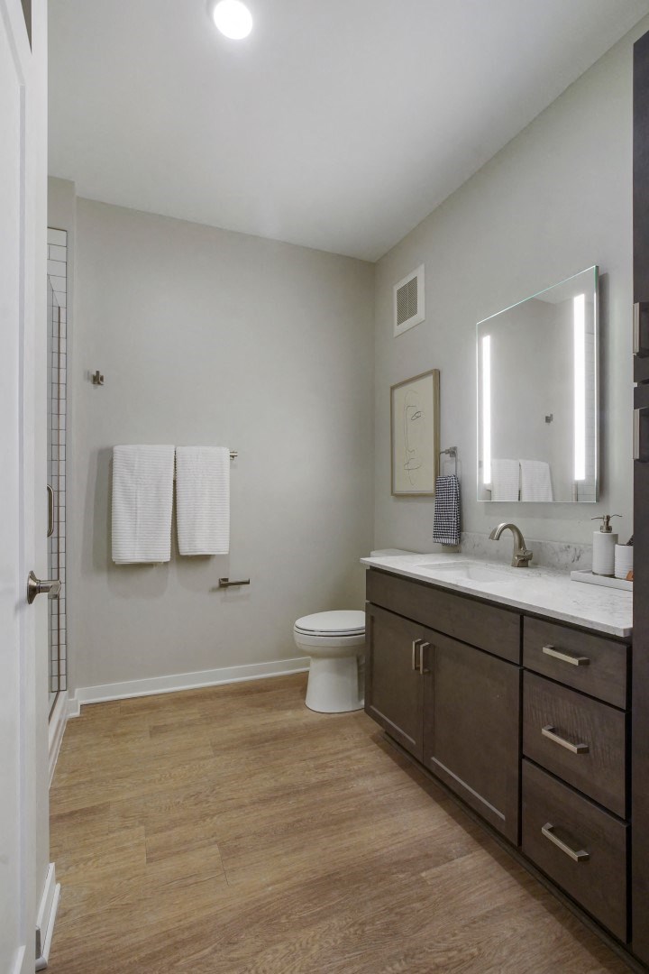 a bathroom with gray walls and a wooden floor