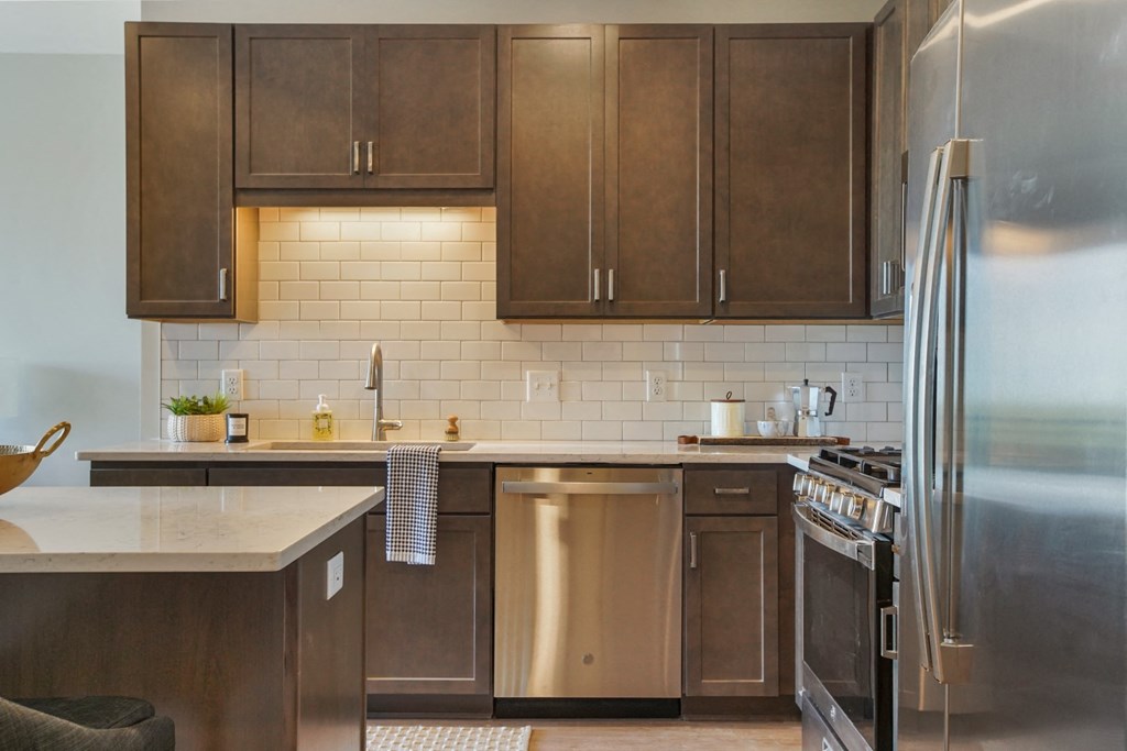 a kitchen with wood cabinets and stainless steel appliances