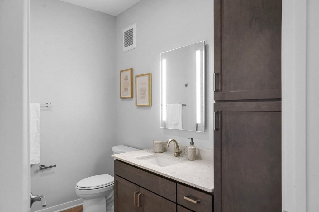 a bathroom with gray walls and a white sink and toilet