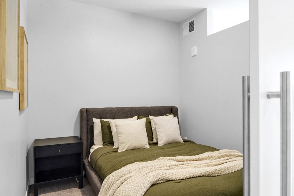 a bedroom with a bed and a nightstand in a 555 waverly unit
