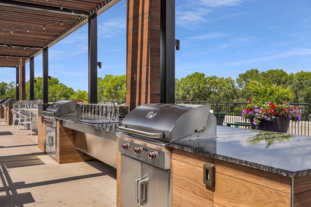 an outdoor kitchen with stainless steel appliances and a bar