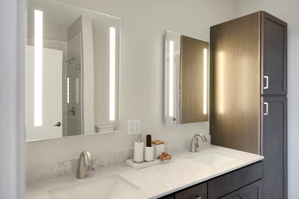 a bathroom with two sinks and two mirrors