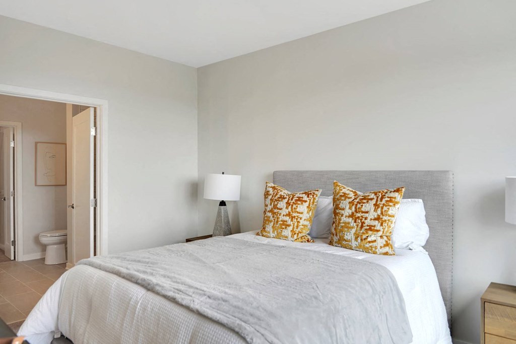 a bedroom with a large bed and a door to a bathroom