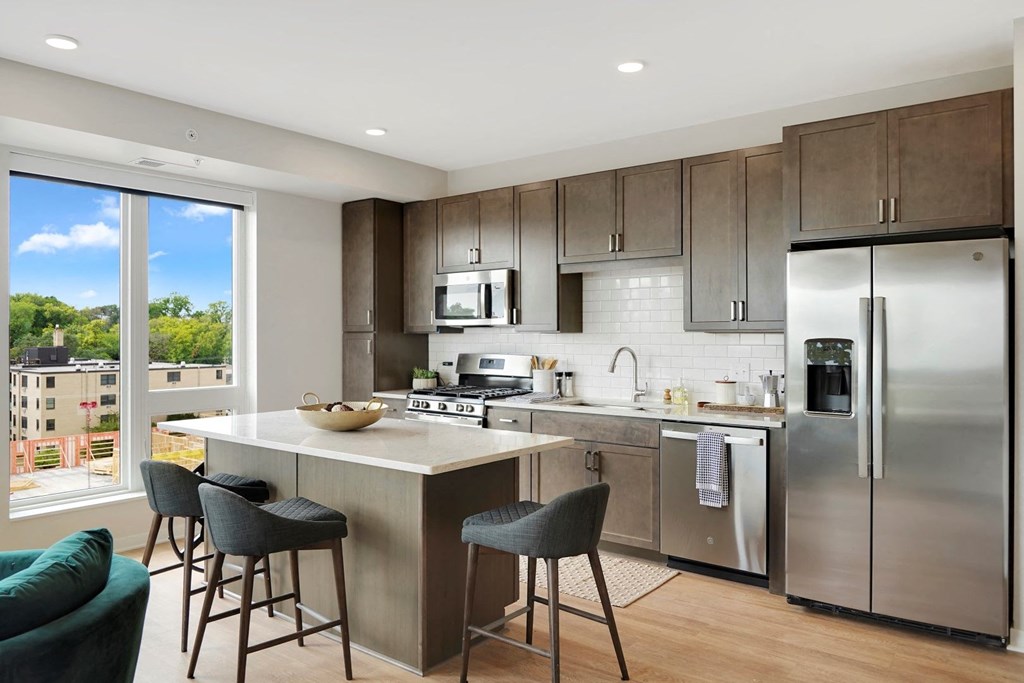 a kitchen with a large island and stainless steel appliances