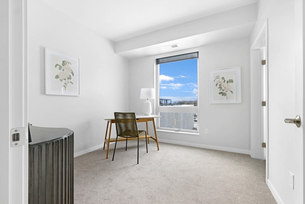 a bedroom with a desk and a window