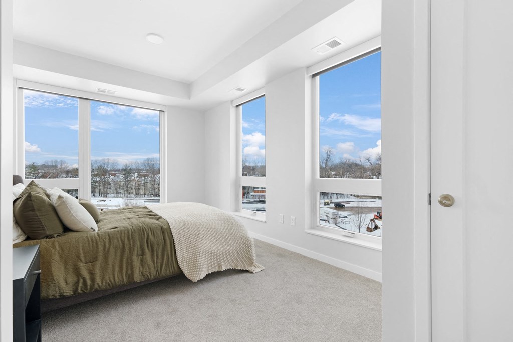 a bedroom with a bed and three windows