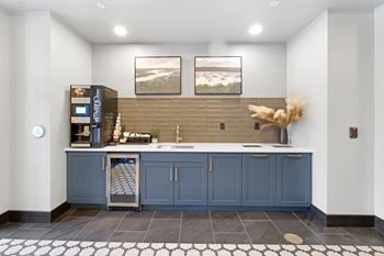 A kitchen with a fridge, a sink, and a counter.