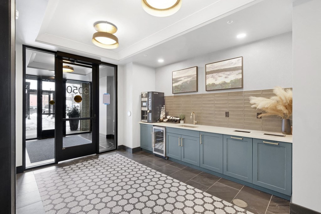 a kitchen with blue cabinets and a black and white rug