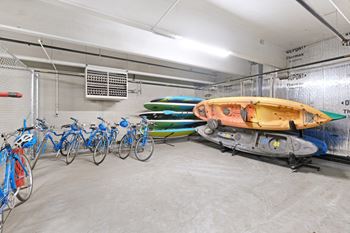 A row of bicycles are parked in a garage.